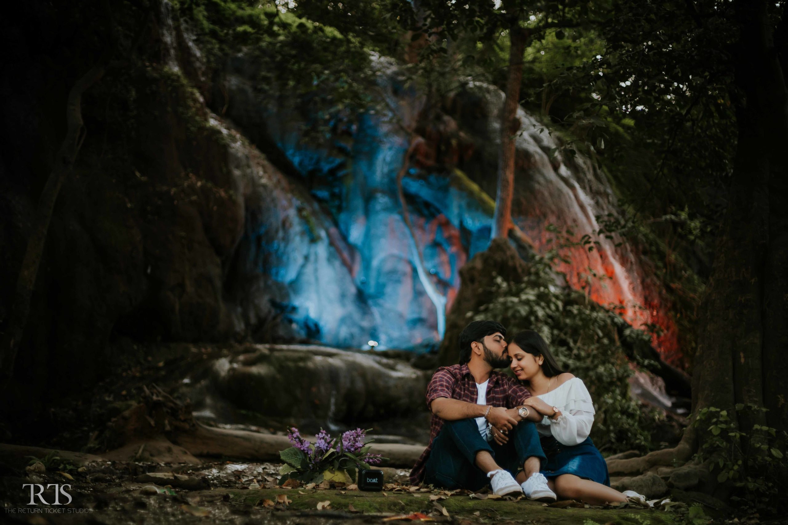 couple sitting a forest with water fall Beautiful candid photography of pre wedding and wedding by The Return Ticket Studios 