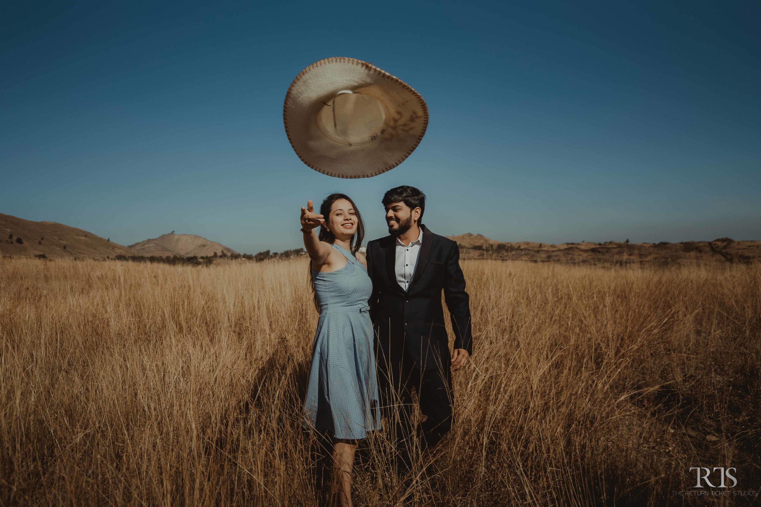 couple walking in the golden grass Beautiful candid photography of pre wedding and wedding by The Return Ticket Studios 