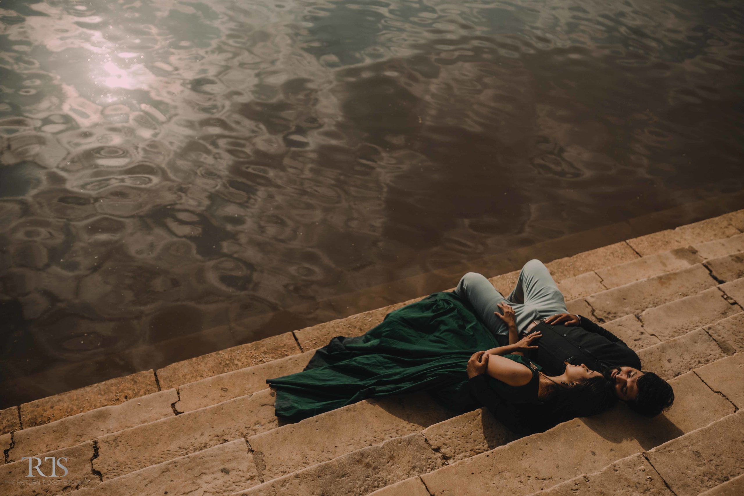 couple sitting near the lake Beautiful candid photography of pre wedding and wedding by The Return Ticket Studios 