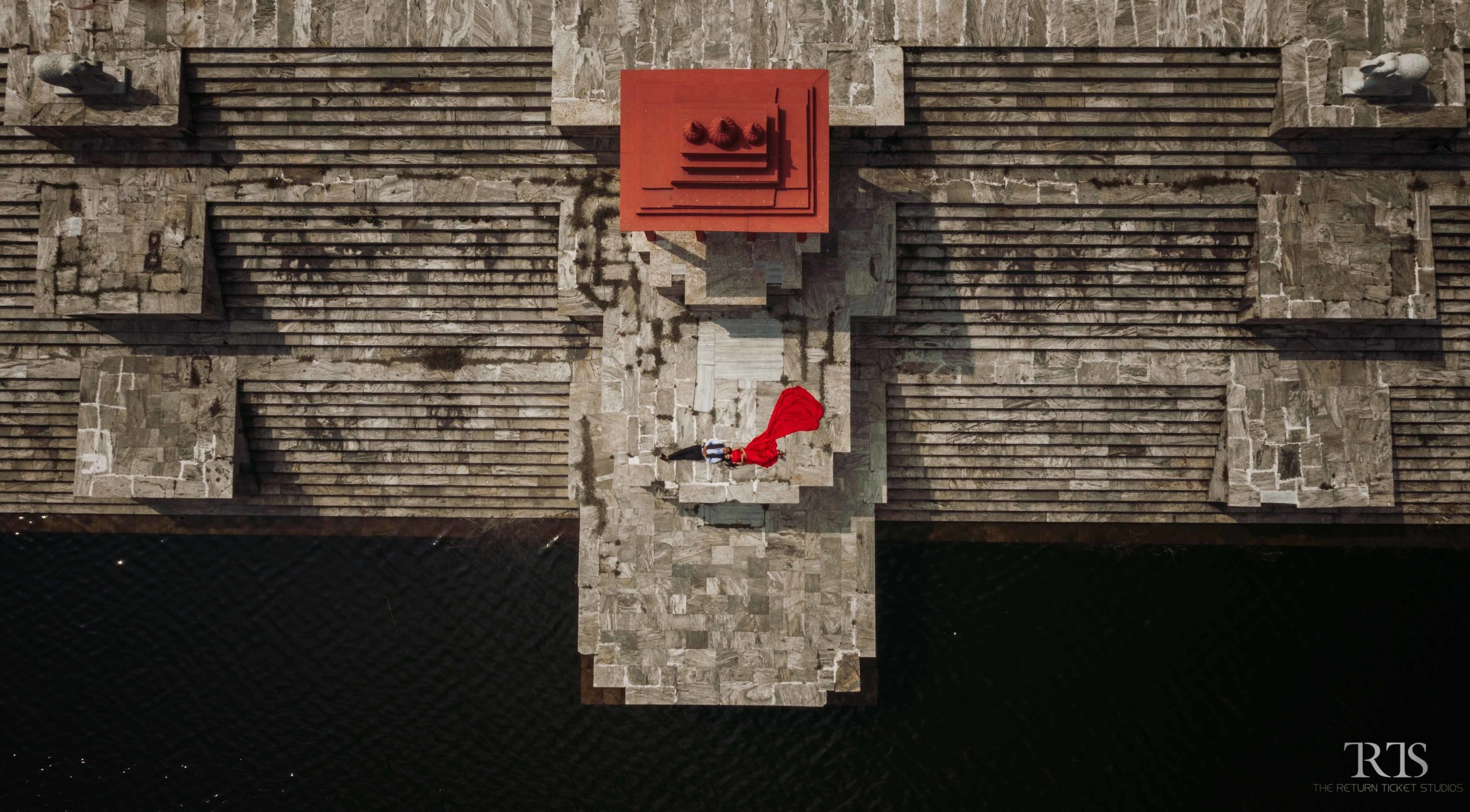 aerial shot of couple near by lake wearing red dress Beautiful candid photography of pre wedding and wedding by The Return Ticket Studios 