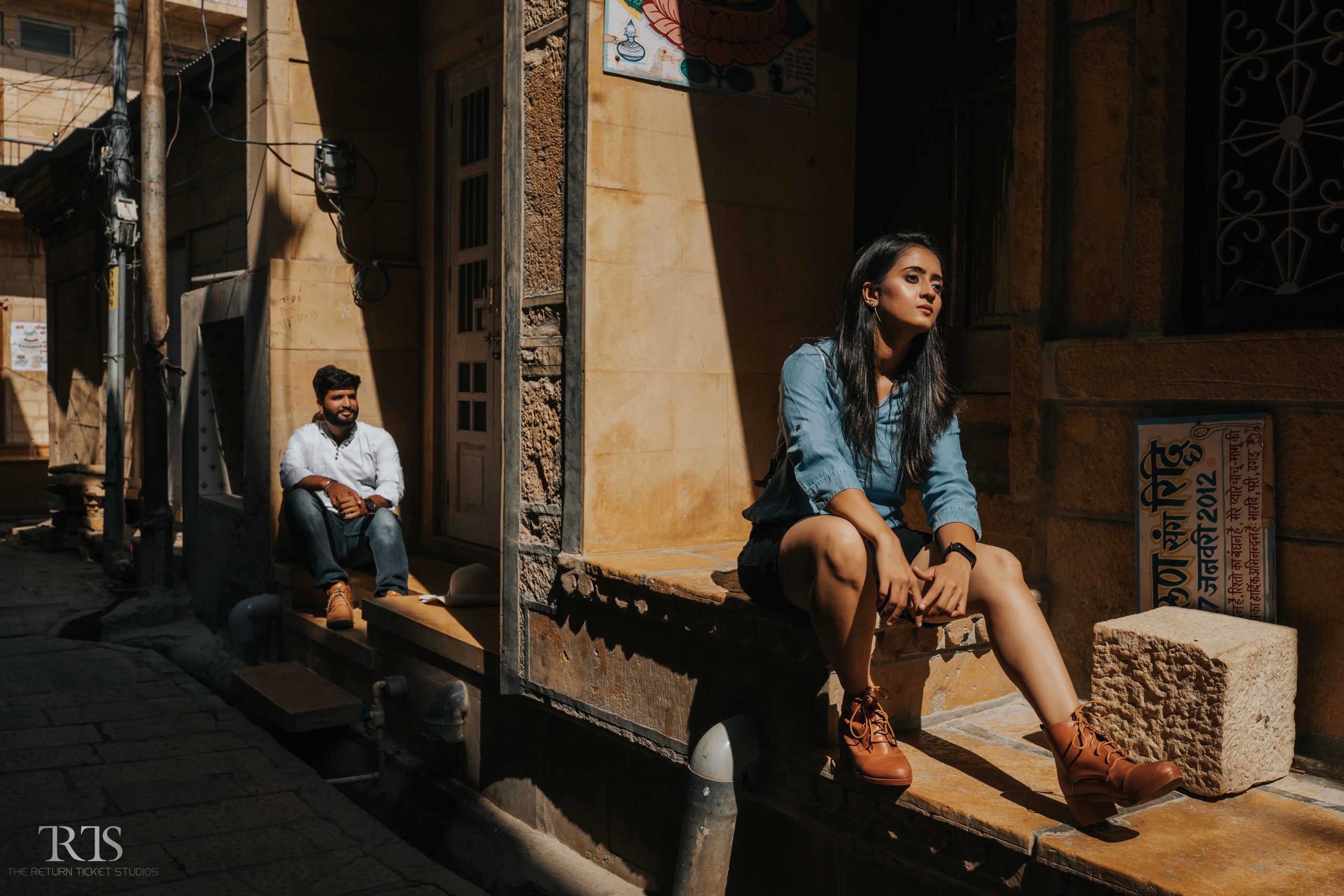 couple sitting in the jaisalmer street with leather shoes and jacket