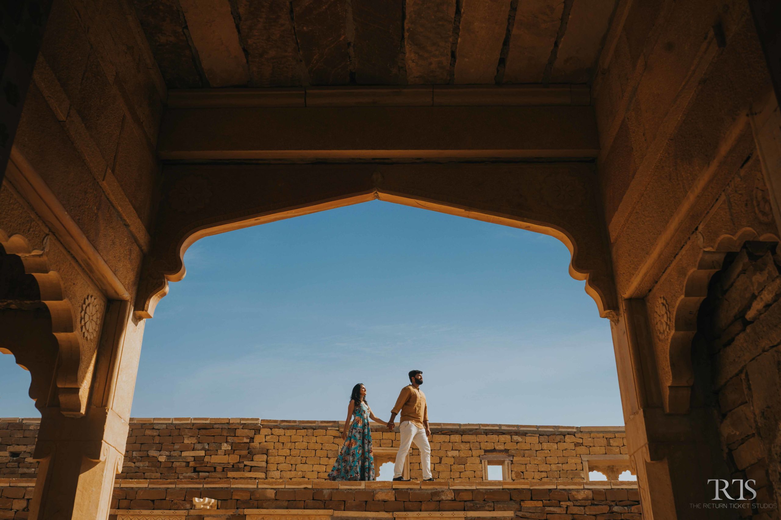 couple walking in the street of jaisalmer Beautiful candid photography of pre wedding and wedding by The Return Ticket Studios 